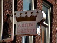 820078 Afbeelding van het uithangbord Warme Bakker aan de voorgevel van het pand Vismarkt 2 (Bakkerij Boonzaaijer) te ...